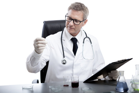 scientist or doctor is looking and analyse blood test tube, in lab or hospitalの写真素材