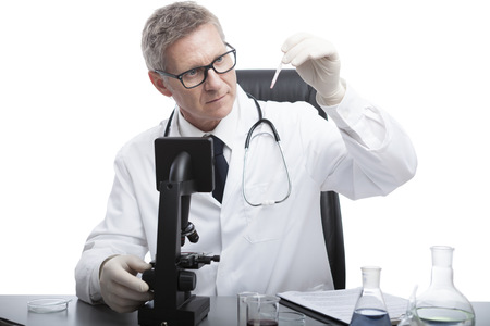 scientist or doctor is looking and analyse blood test tube, in lab or hospitalの写真素材