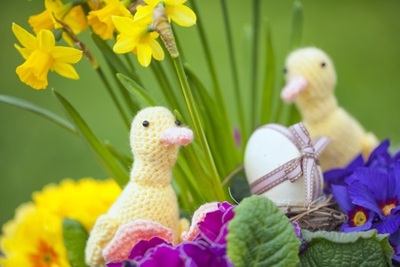 cute floral decoration with little hand made duck and Easter egg outdoors in gardenの写真素材