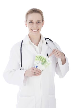 Close up Portrait of a Happy Woman Doctor Holding Cash in Fan and Stethoscope on her Shoulders While Looking at the Camera. Isolated on a White Background.の写真素材