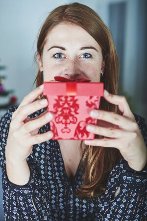 young girl hide behind christmas present boxの写真素材
