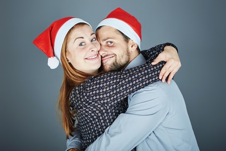 young happy couple hug and love christmas in frot of grey backgroundの写真素材