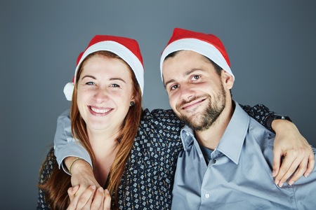 young happy couple hug and love christmas in frot of grey backgroundの写真素材