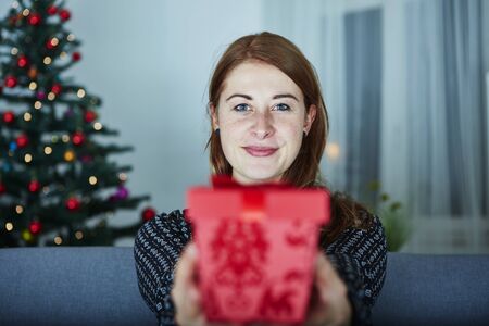 young girl hide behind christmas present boxの写真素材