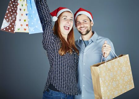 young couple got some present bags at christmas and is very happy about itの写真素材