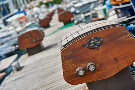 Wooden steering wheel of a sailboat on the marina.