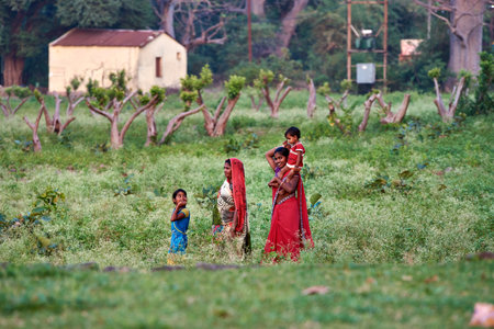 Unidentified indian girls in traditional clothes playing music on the field.