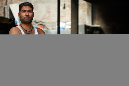 Portrait of a handsome Indian man in sportswear looking at camera