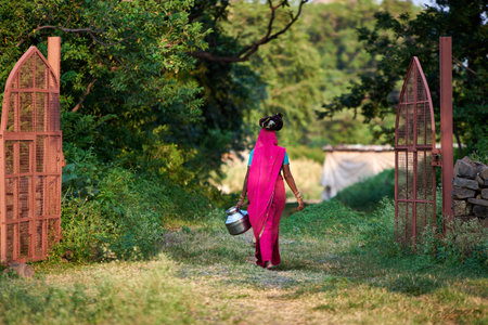 Young indian woman in saree with a watering can in her handのeditorial素材