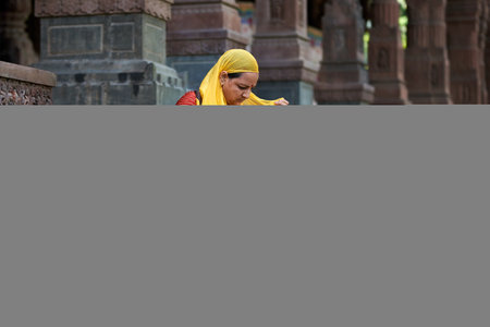 Unidentified Hindu woman in yellow dress at the Pashupatinath temple in Kolkata, West Bengal, India.のeditorial素材