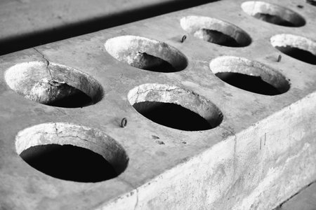 closeup of a concrete wall with holes in black and white.