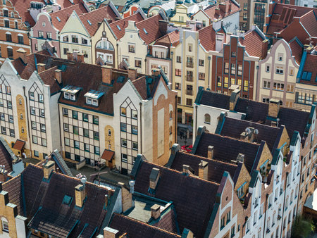 Close-up of restored townhouses with arched windows and colorful walls in ElblÄ…g