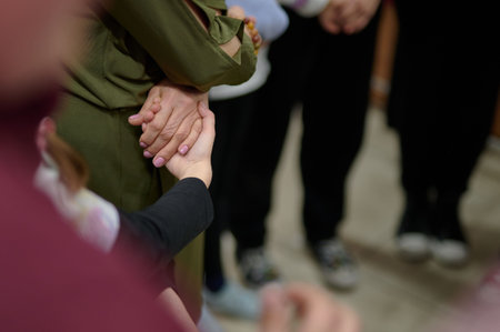 Close up of a group of people holding hands in a circle.