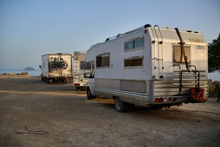 White motorhome parked coastal terrain sea background Mediterranean Spain RV camping adventure vacation lifestyleのeditorial素材