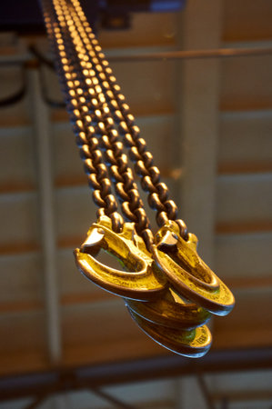 Industrial lifting chains hooks yellow safety equipment construction warehouse machinery metal...