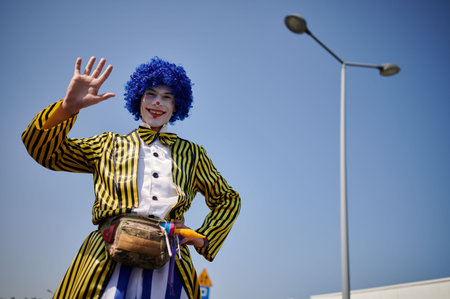 Colorful street performer waving during harvest festival in Wloclawek, Poland, captured in daylight...