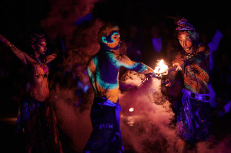 Group of fire dancers surrounded by smoke and flame perform during Los Fuegos Fire Theater in...