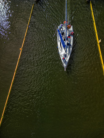 Top-down drone HDR photo of sailboat aligned in Guzianka canal, vertical composition for travel...