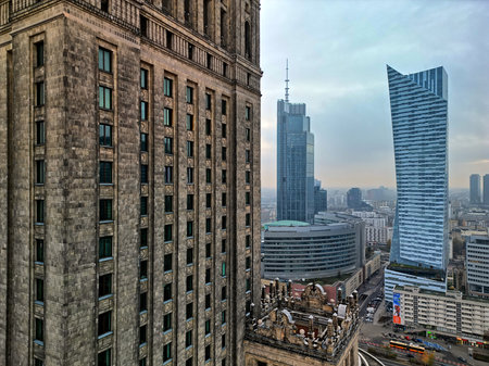 Drone perspective of the Palace of Culture and Science in Warsaw with the curved façade and the surrounding modern cityscape under the evening sky.の写真素材