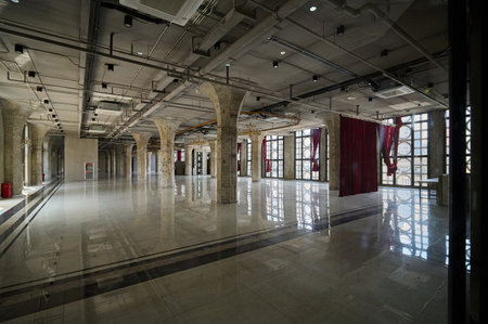Museum exhibition display floor reflecting overhead brutalist concrete architecture and natural...
