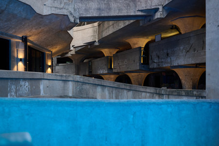 Concrete tunnel underground passage with blue water pool and industrial architectureのeditorial素材