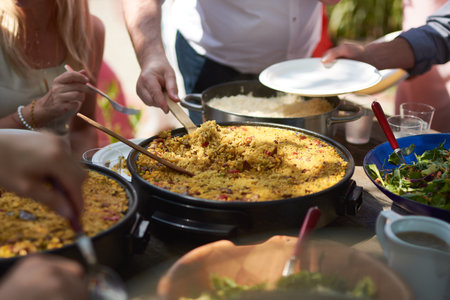 People Serving Paella and Rice at Outdoor Garden Party