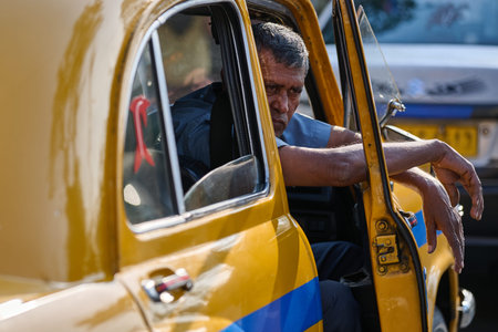 Taxi driver resting in yellow car on city streetのeditorial素材
