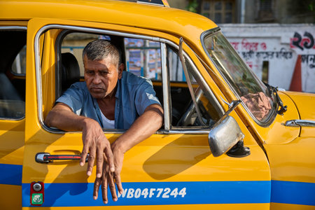 Man in yellow taxi looking out window in Kolkata