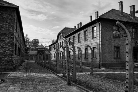 Barbed wire fence and brick barracks at Auschwitz camp