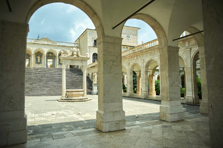 The central courtyard and arched cloisters of the Abbey of Monte Cassino with a stone well, Cassino,...