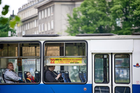 Passengers and a child inside a blue city tram displaying the route to Borek Falecki, Krakow, Malopolska, Poland, Europe.のeditorial素材