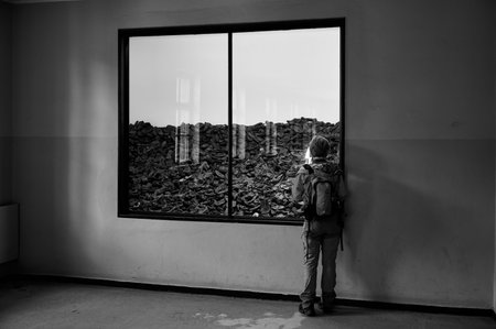 Visitor looking at pile of shoes in Auschwitz museum exhibit