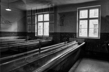 Washroom with long ceramic troughs in Auschwitz museum barracks
