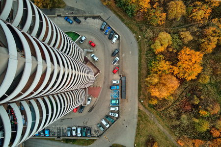 Aerial top-down view of a Kukurydze apartment skyscraper overlooking a parking lot and autumn forest, Katowice, Slask, Poland, Europe.のeditorial素材