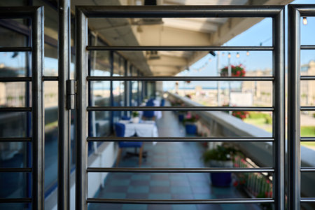 Framed view through a metal barrier leading to the outdoor terrace at Roza Wiatrow restaurant in Gdynia, Poland