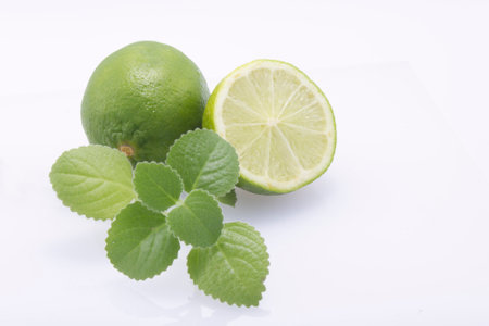 Fresh, natural, green limes, cut in half and whole, fresh mint on a white background.の写真素材