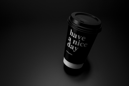 A plastic cup for coffee with a lid on a black backgroundの写真素材