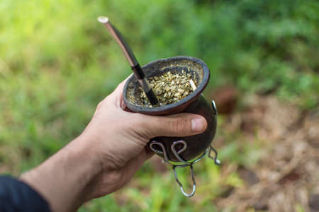 hand grabbing a bowl of mate, yerba mateの写真素材