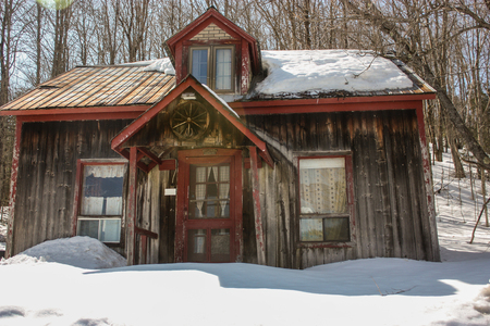 old house with snow in the woodの写真素材
