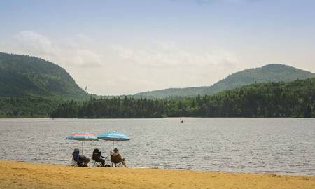 3 peoples sitting at the beach in the woodsの写真素材