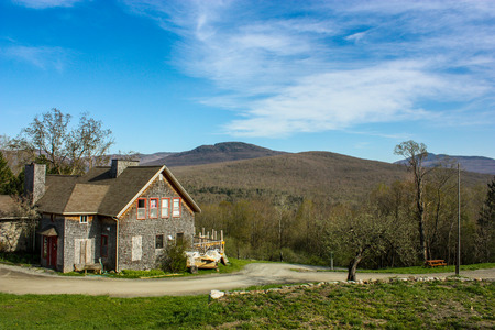 big cottage on top of a hill looking at mountainsの写真素材