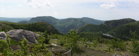 top of a mountain view with lake and mountain range in distanceの写真素材