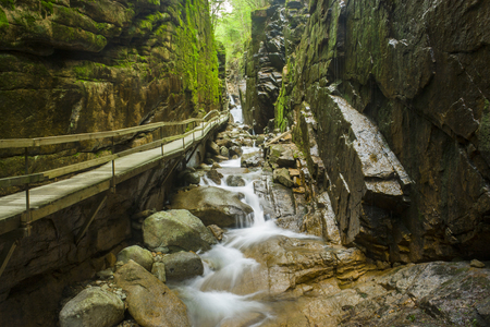 long suspended bridge over surrounded by rocks in new hampshireの写真素材