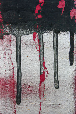 black and red graffiti drips on white wallの写真素材