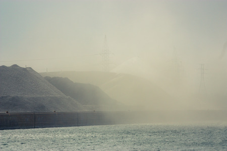 piles of rocks blowing dust in the river