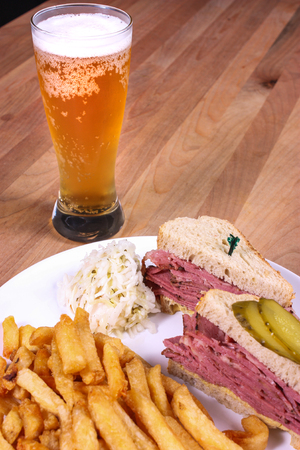 smoked meat sandwich with fries and a beerの写真素材