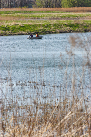 two fishermen in a boat on a riverの写真素材