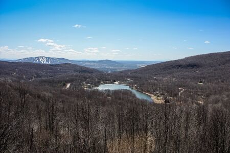 view of a lake and ski slopes from the top of a mountainの写真素材