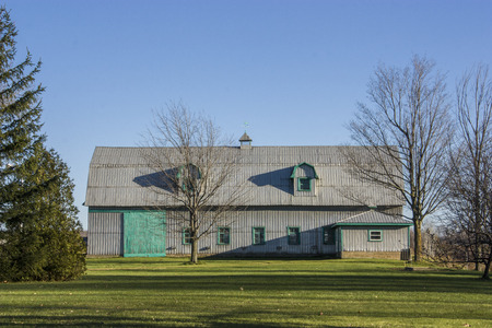 farm building with green grass and blue skyの写真素材