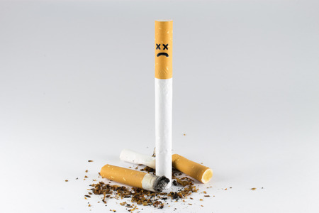 Vertical standing cigarette with cross face around cigarette butts.
